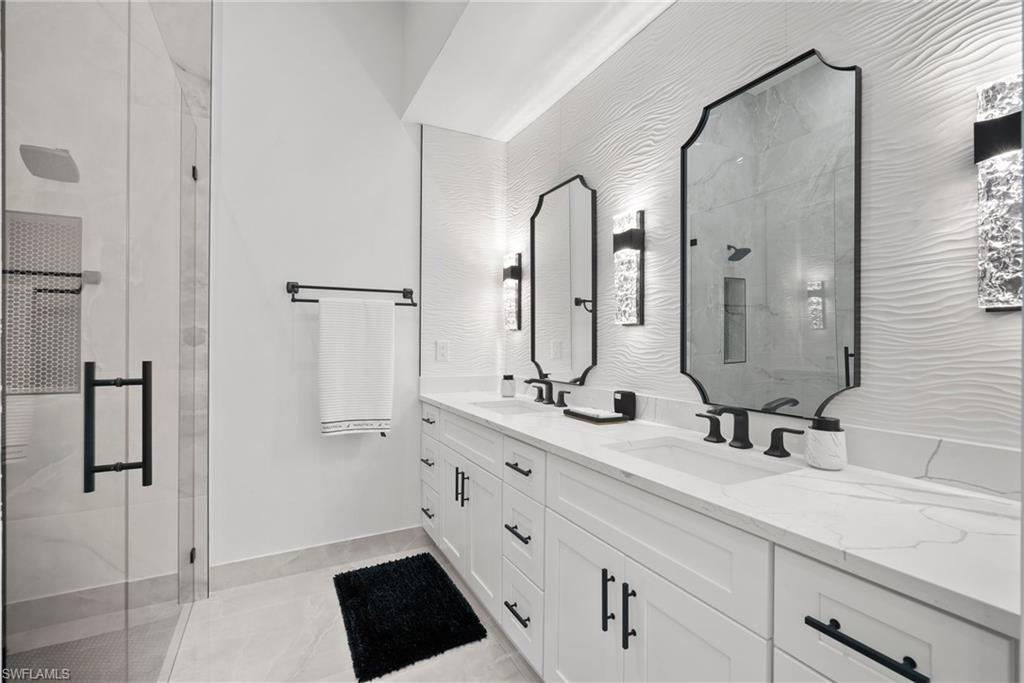 Bathroom with a shower with door, vanity, and tile patterned flooring