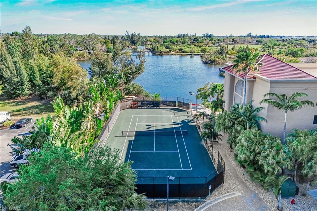 Lighted Har-tru tennis court with lake view and pavillion