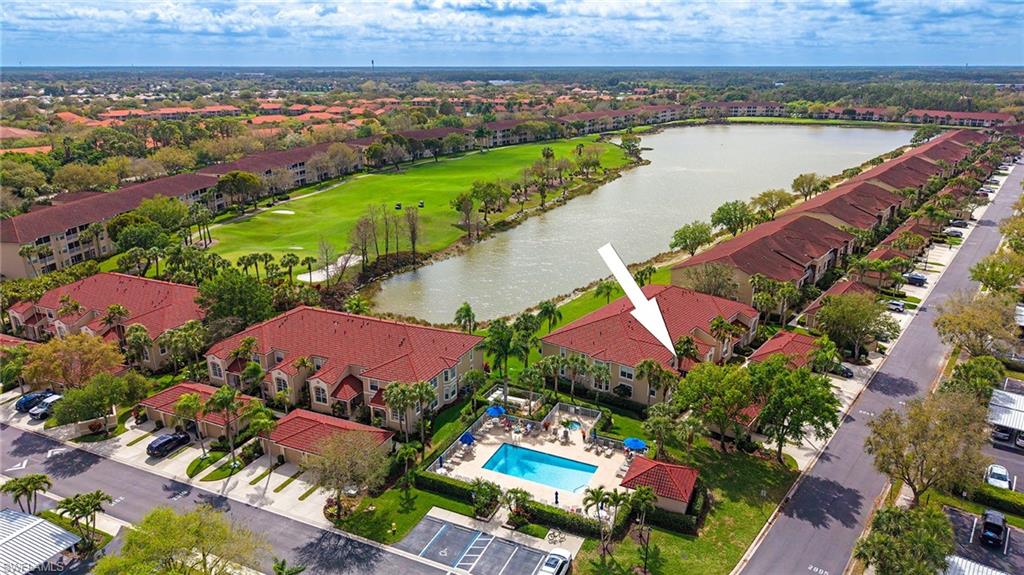 Aerial view of residential area with a nearby body of water and a golf club