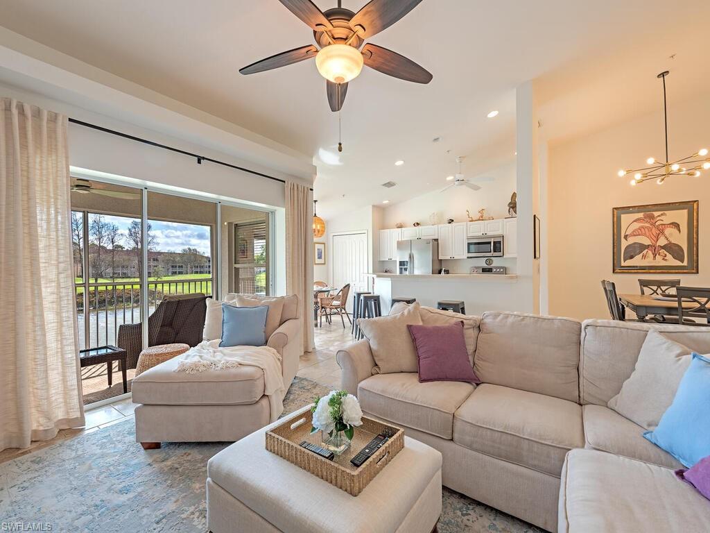 Living area with ceiling fan, lofted ceiling, suspended lighting.