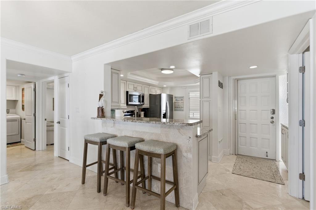 Entry door in foreground and a kitchen to entertain friends and family.  Photo Digitally Enhanced