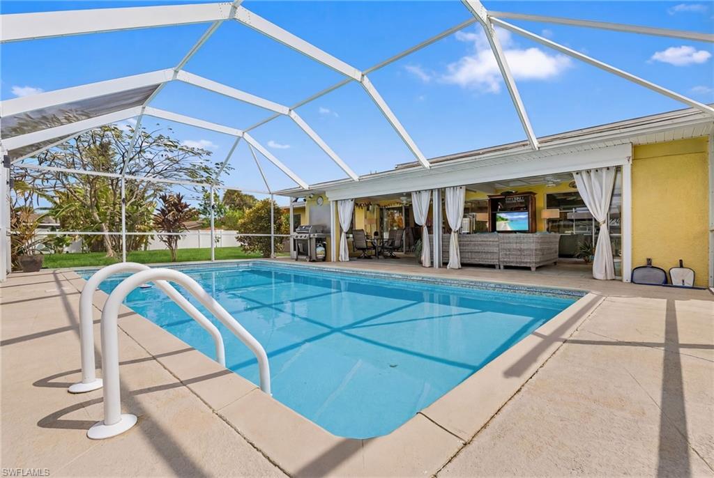 Outdoor pool featuring a lanai, a patio, grilling area, a sunroom, and outdoor lounge area
