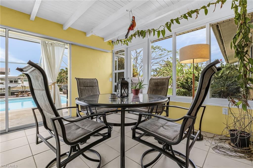 Sunroom featuring beamed ceiling, healthy amount of natural light, and french doors
