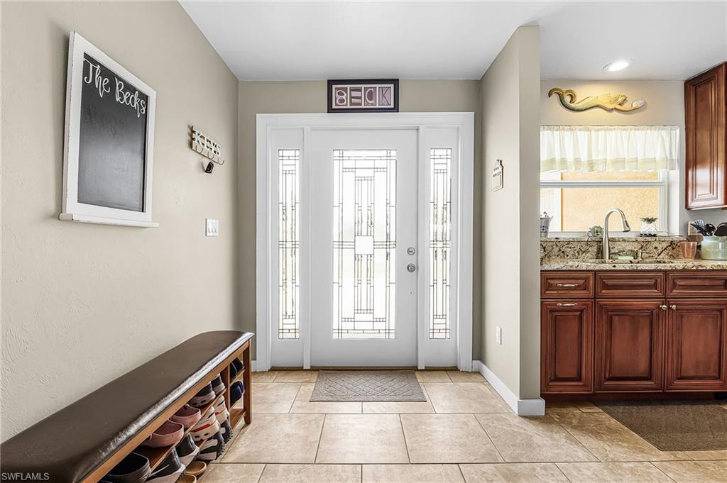 Foyer with light tile patterned flooring