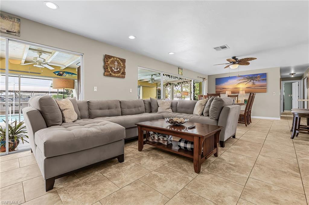 Living area with a ceiling fan, recessed lighting, and light tile patterned floors