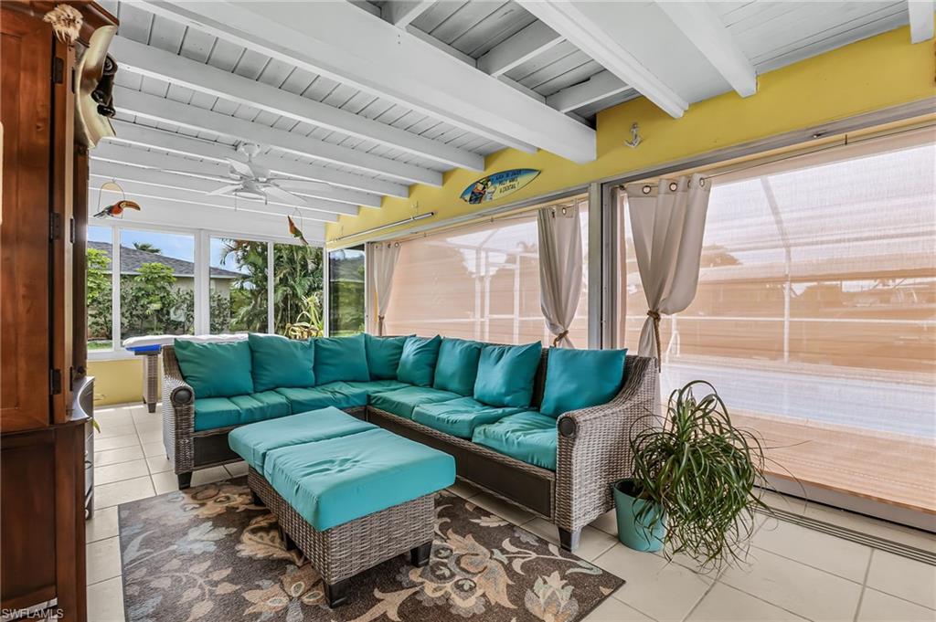Sunroom / solarium featuring outdoor lounge area, ceiling fan, and beamed ceiling