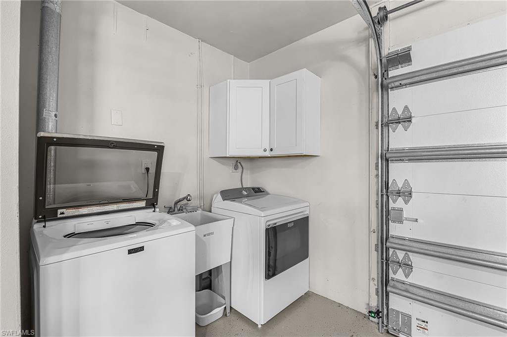 Laundry area with washer / dryer, cabinet space, and concrete flooring