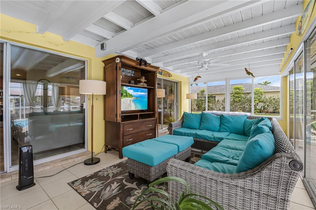 Sunroom with an outdoor lounge area, a ceiling fan, and beam ceiling