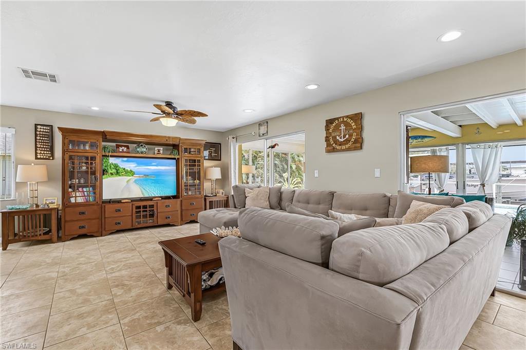 Living area featuring a ceiling fan, recessed lighting, and light tile patterned flooring