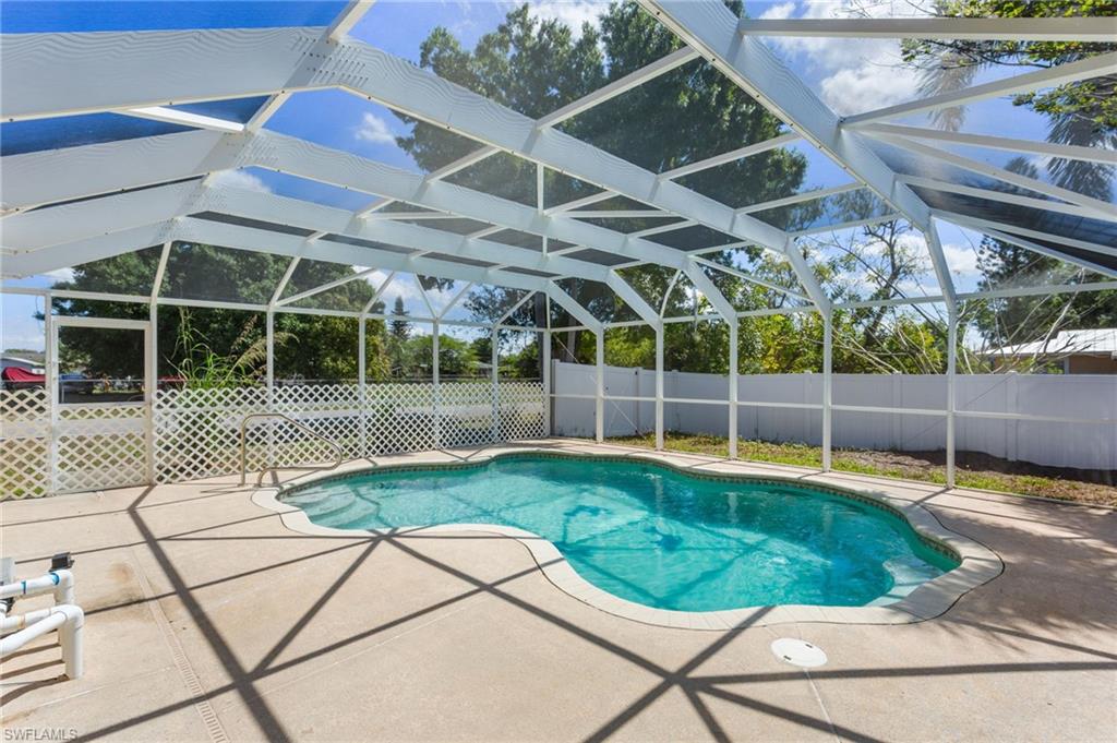 View of swimming pool featuring a fenced backyard, a sunroom, patio surround, and screen enclosure.