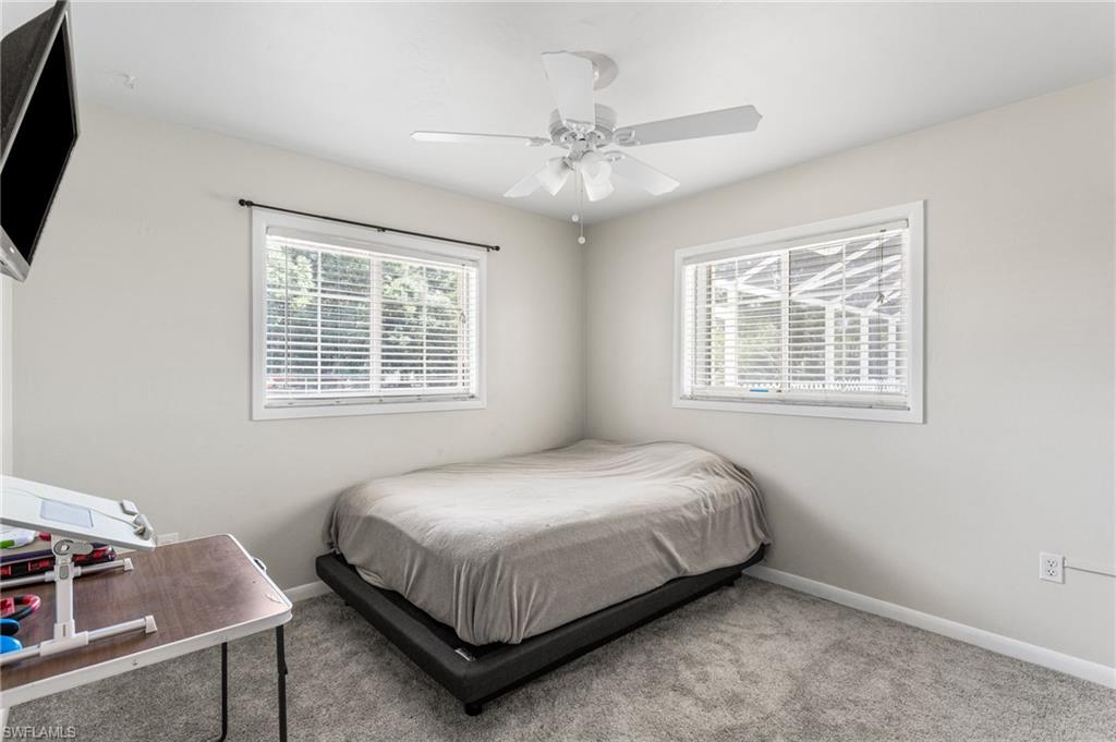 Carpeted bedroom featuring a ceiling fan and baseboards