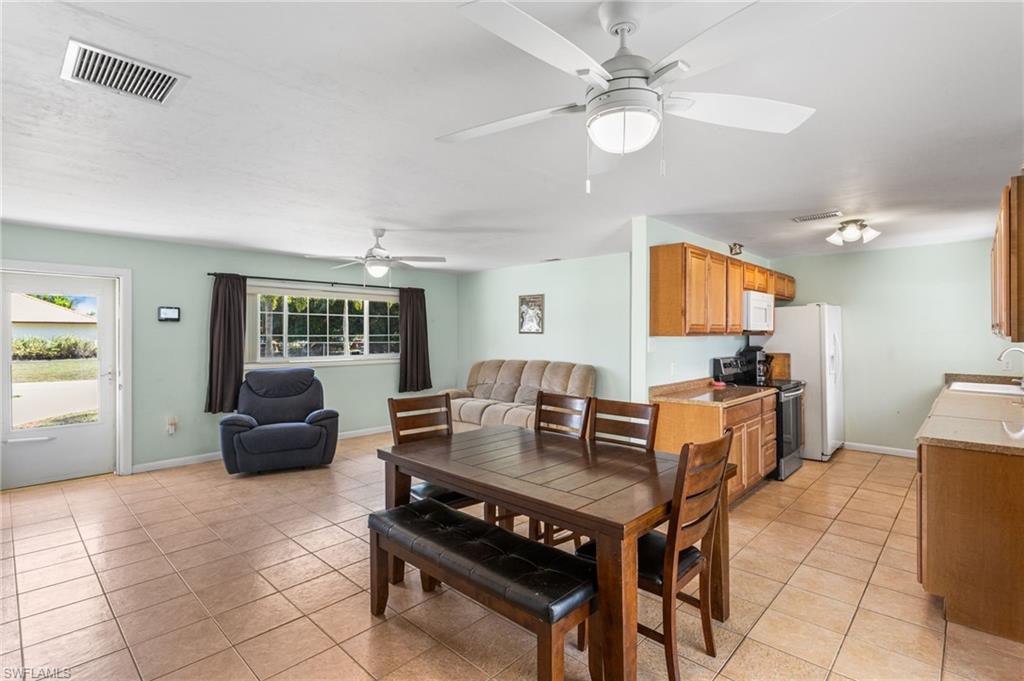 Dining room with light tile patterned floors and a ceiling fan