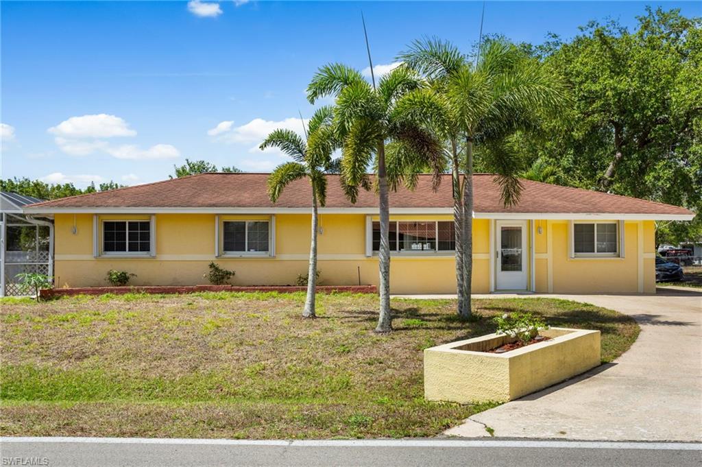 Ranch-style home with stucco siding, concrete driveway, screened pool cage.