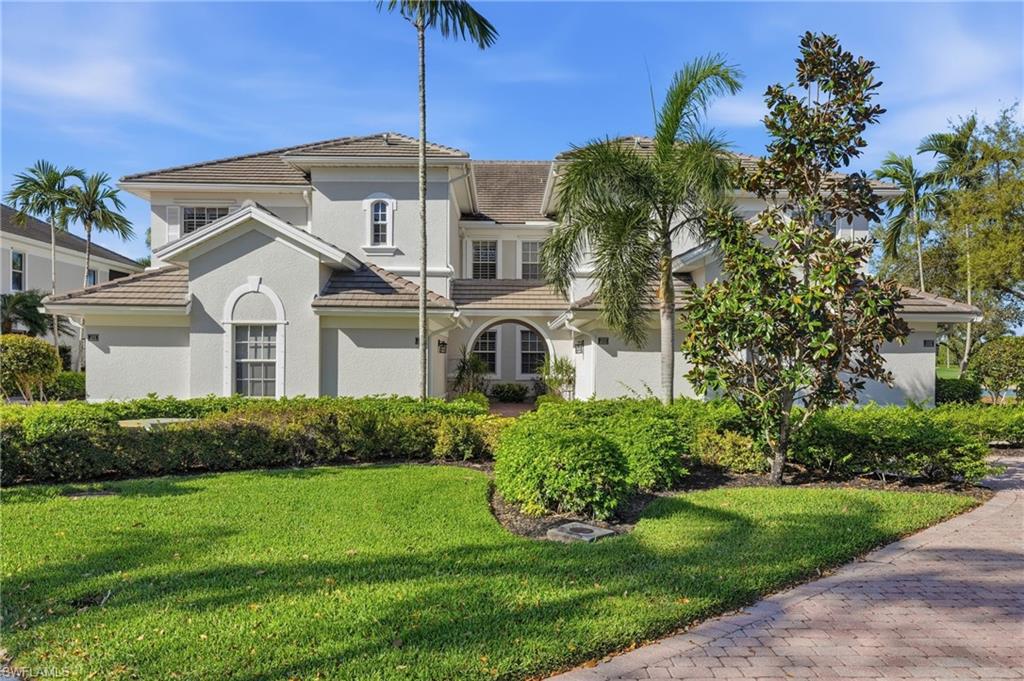 Mediterranean / spanish house with a tile roof, a front yard, and stucco siding
