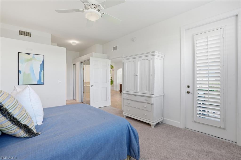 Bedroom with a ceiling fan and light carpet