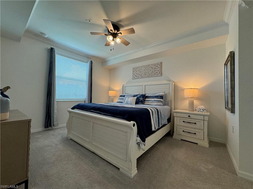 Bedroom featuring ceiling fan, light colored carpet, and crown molding