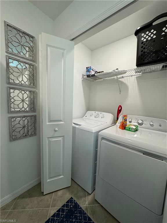 Laundry area featuring washing machine and clothes dryer and tile patterned flooring