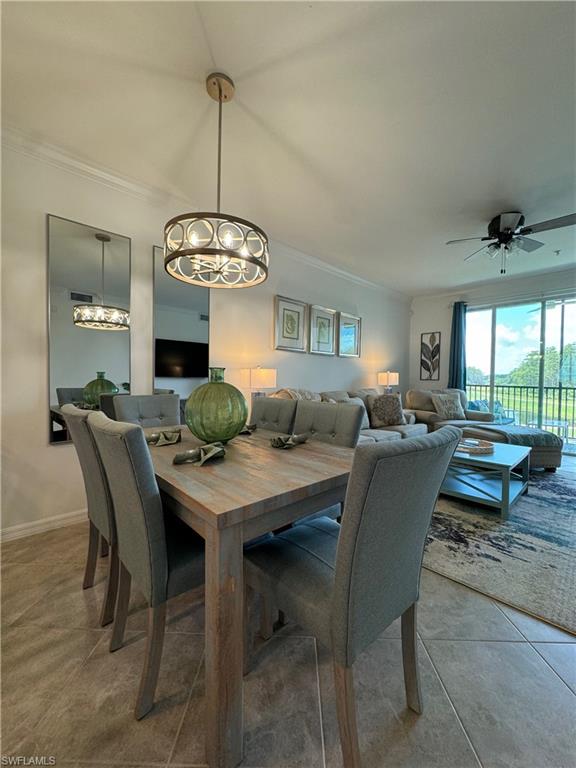 Tiled dining space featuring ceiling fan with notable chandelier and ornamental molding
