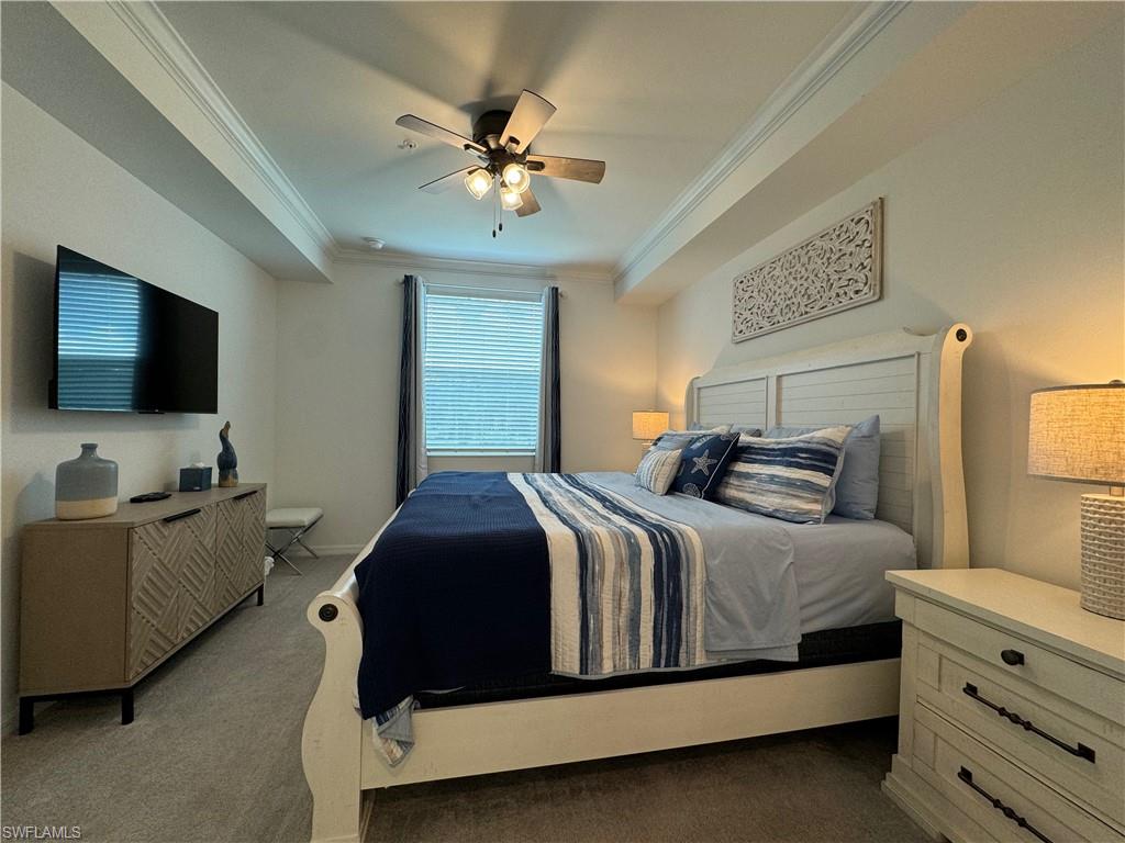 Carpeted bedroom with crown molding and ceiling fan