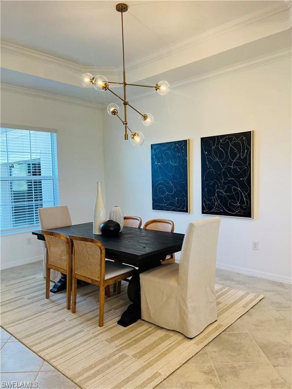Dining room featuring a chandelier, ornamental molding, and light tile floors