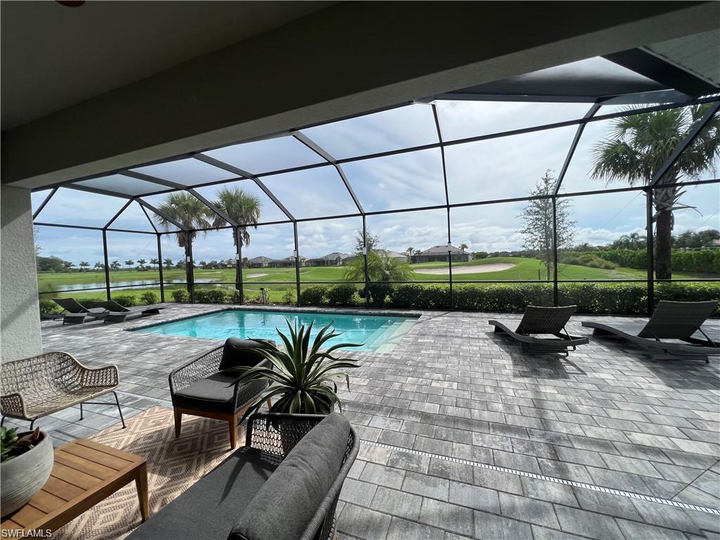 View of pool with a lanai and a patio