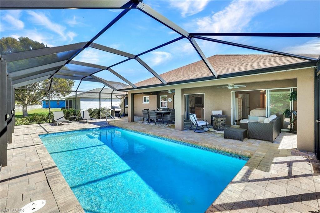 Swimming pool featuring a sunroom, a patio, glass enclosure, and outdoor lounge area