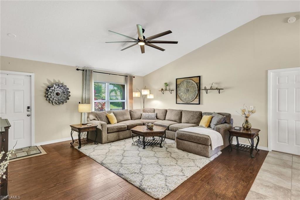 Living area featuring wood finished floors, vaulted ceiling, and ceiling fan