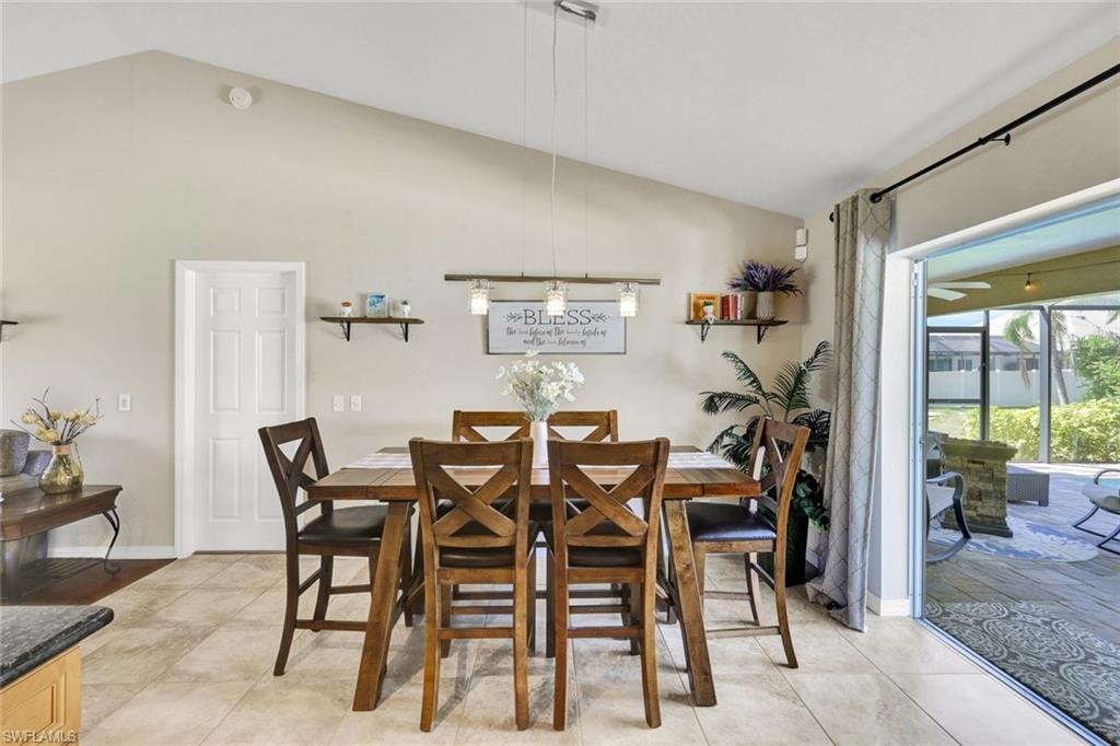 Dining space featuring vaulted ceiling and baseboards