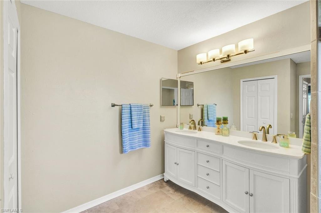 Full bathroom with double vanity and a closet
