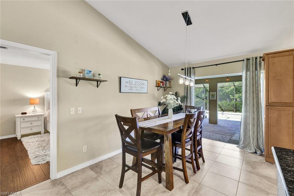 Dining room featuring vaulted ceiling and light tile patterned flooring