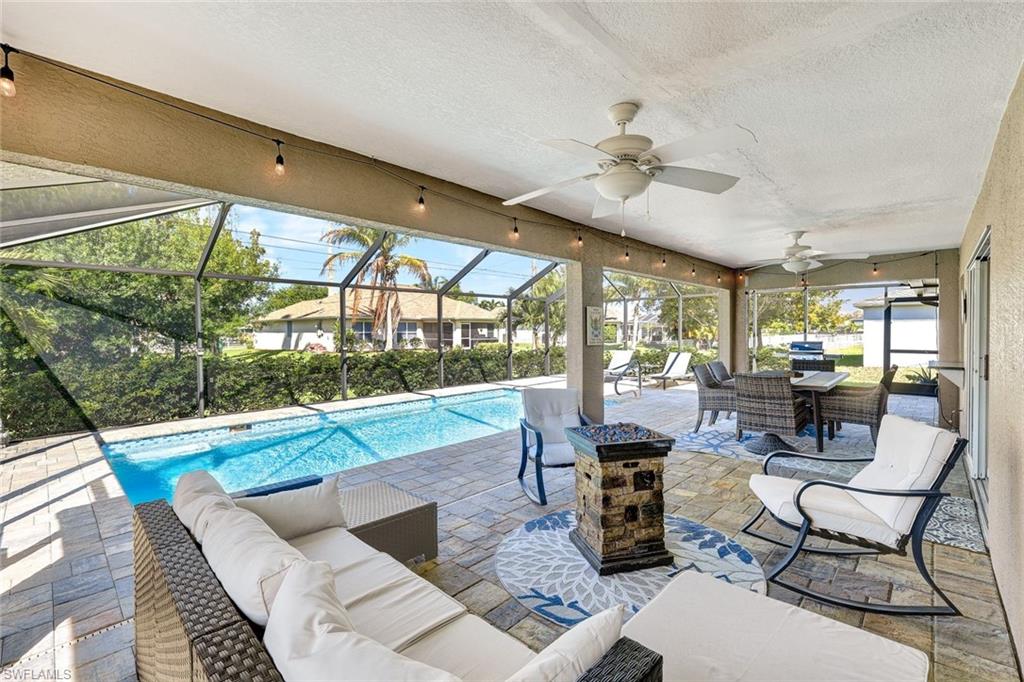 Outdoor pool with a patio, an outdoor living / dining area, a sunroom, and glass enclosure