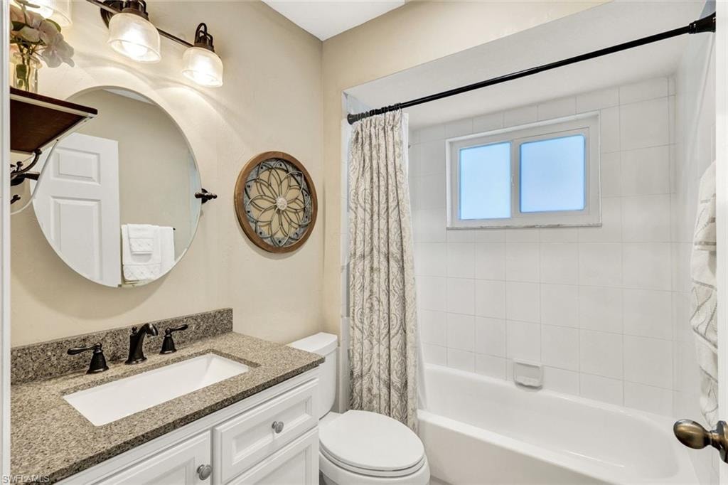 Bathroom featuring vanity and shower / bath combo with shower curtain