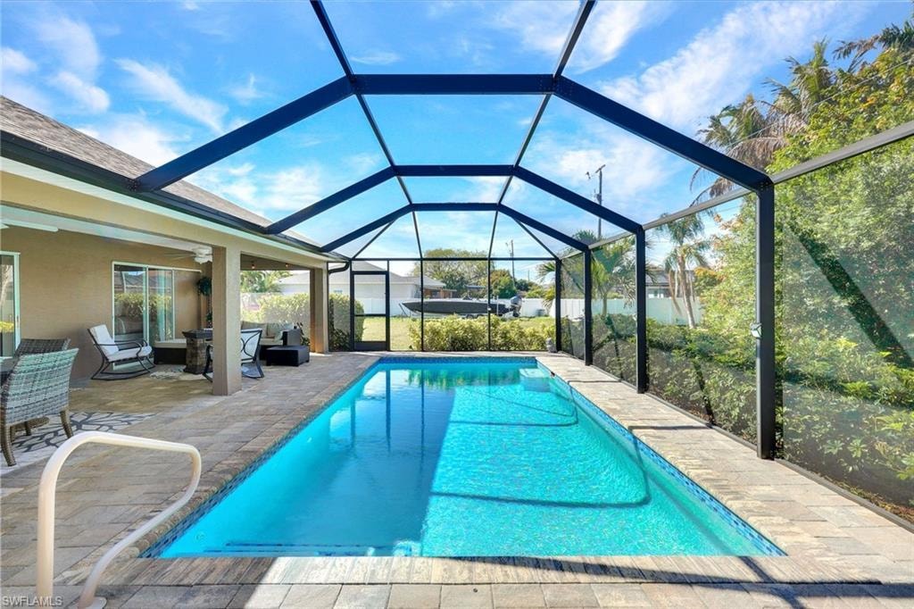 Outdoor pool featuring a sunroom, a patio area, a lanai, and outdoor furniture