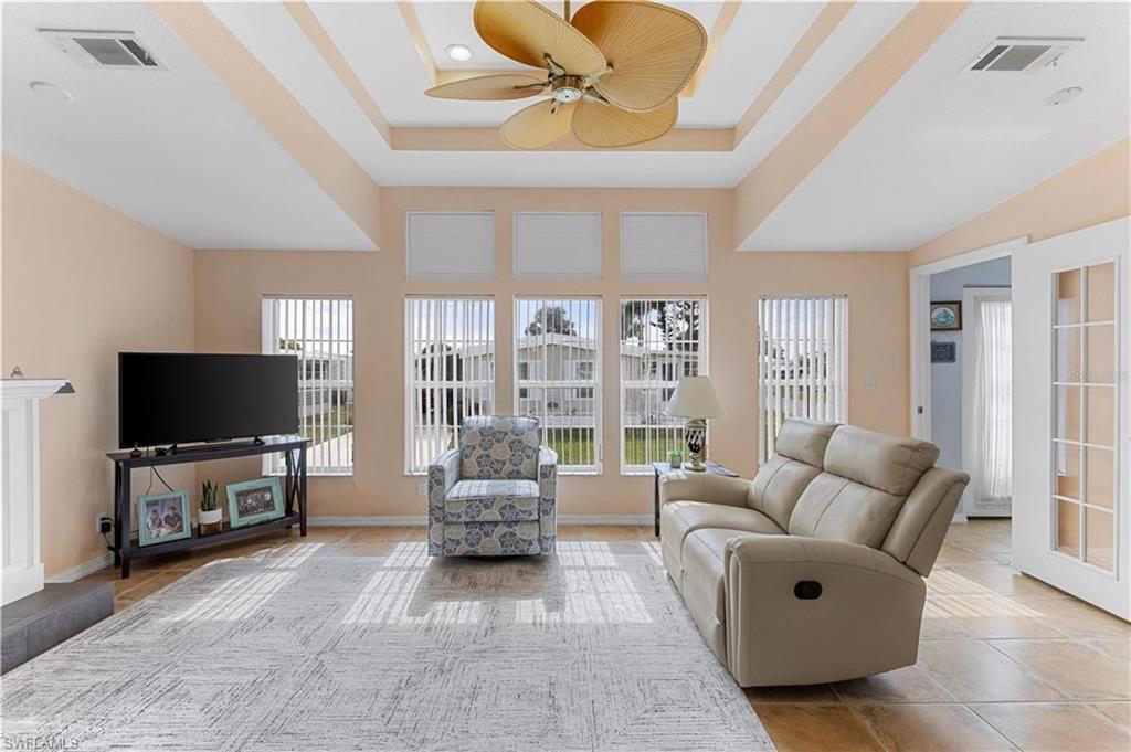 Living area with ceiling fan and light tile patterned flooring