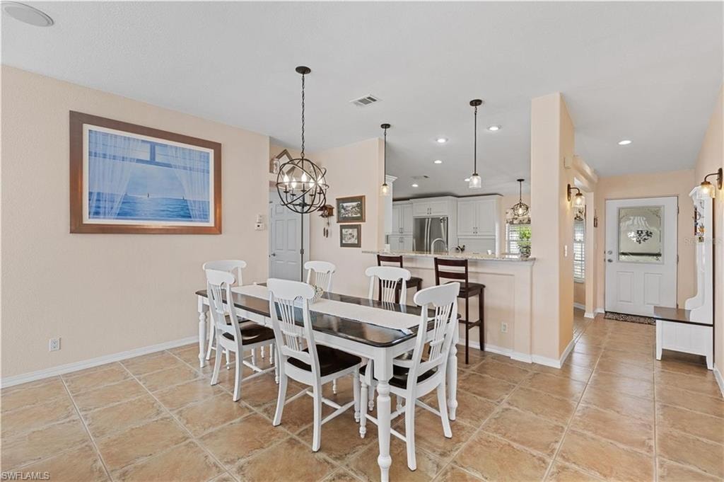 Dining room with suspended lighting and light tile patterned flooring
