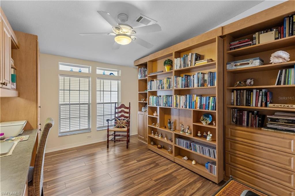 Sitting room with ceiling fan and dark wood finished floors