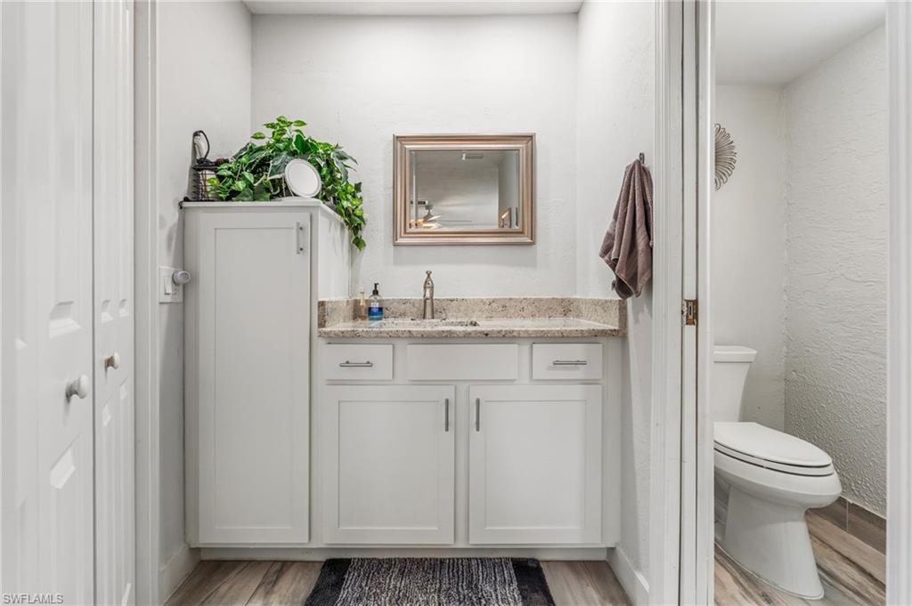 Bathroom featuring vanity, light wood-style floors, and a textured wall
