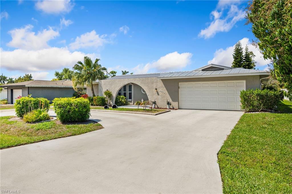 View of front of house with stucco siding, concrete driveway, and a garage