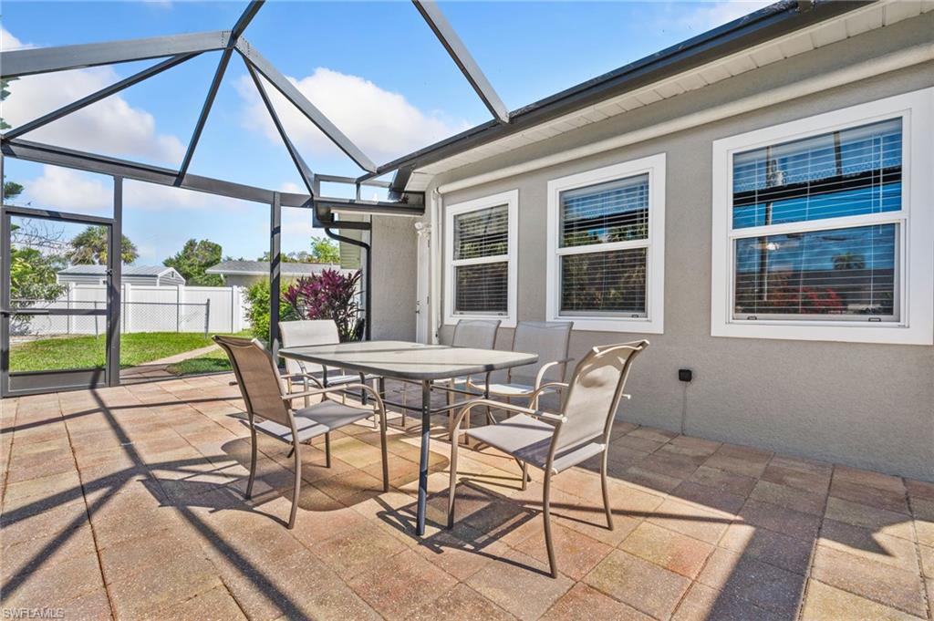 View of patio featuring a sunroom, glass enclosure, and outdoor dining area