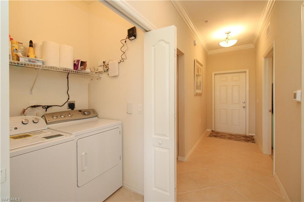 Laundry area featuring visible vents, ornamental molding, laundry area, separate washer and dryer, and light tile patterned floors