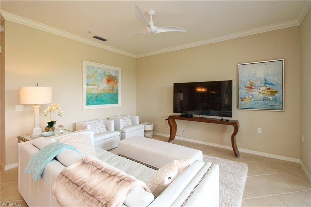 Living room with baseboards, visible vents, a ceiling fan, and light tile patterned floors
