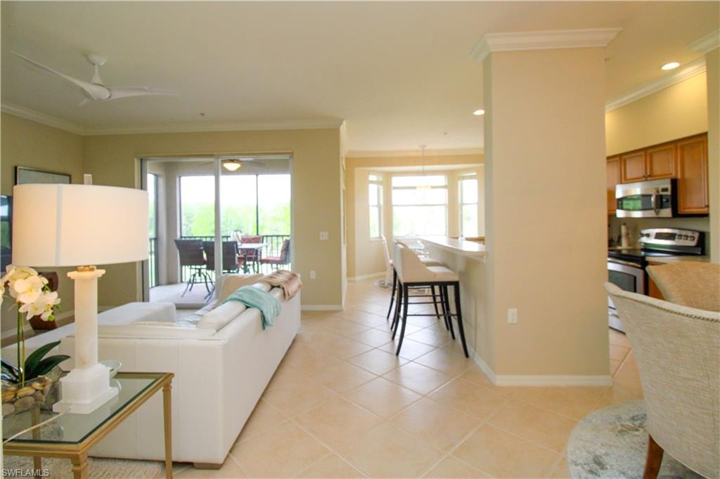 Living room with baseboards, ornamental molding, and light tile patterned floors