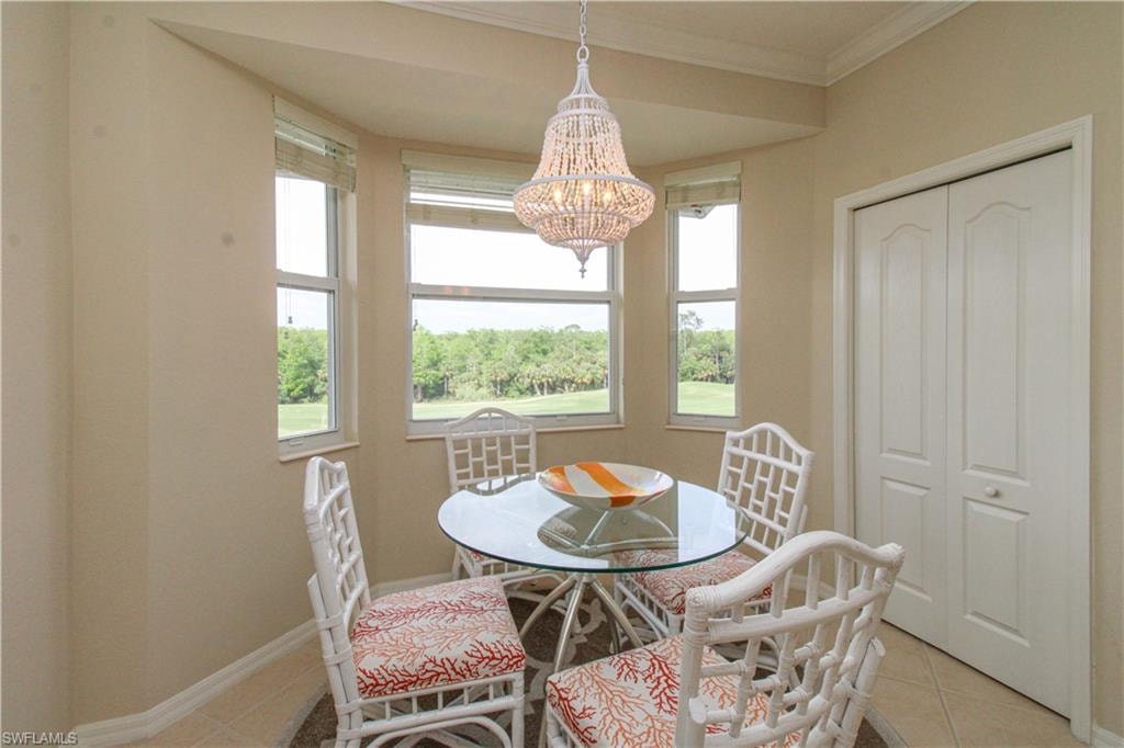 Dining area with an inviting chandelier, light tile patterned floors, plenty of natural light, and baseboards