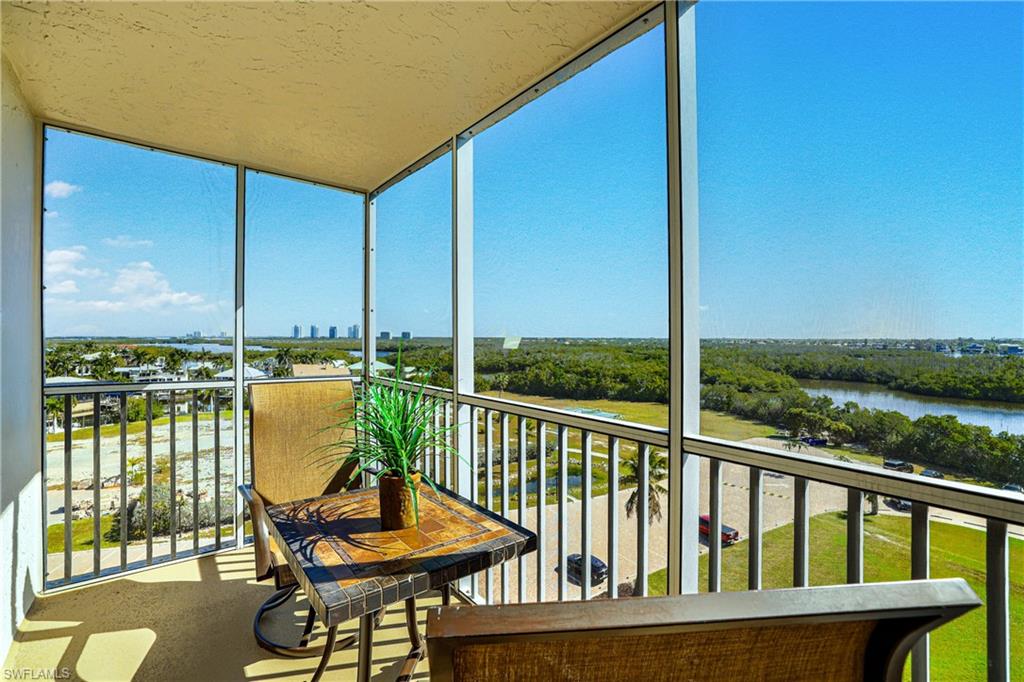 Sunroom featuring expansive windows and a water view