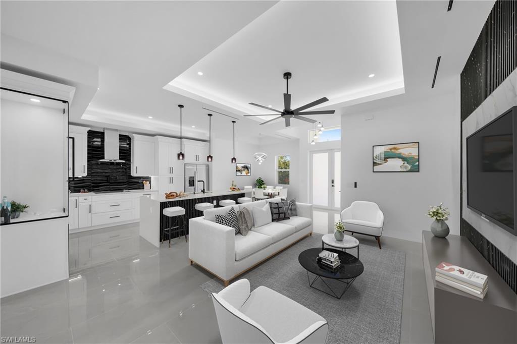 Living area featuring recessed lighting, a ceiling fan, and a raised ceiling