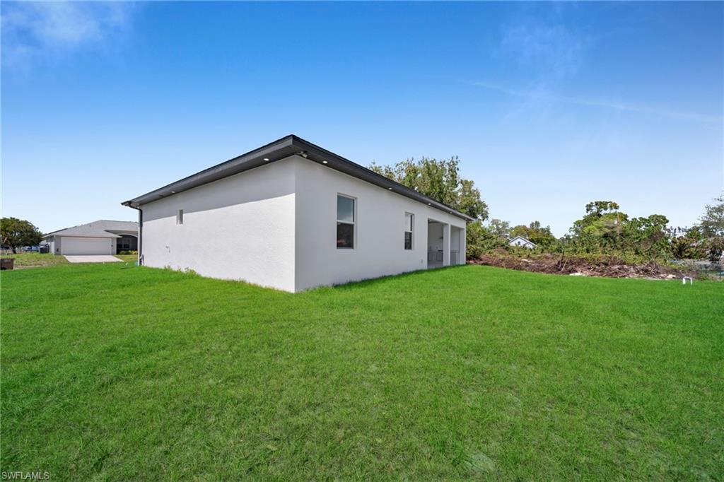View of home's exterior featuring a yard and stucco siding
