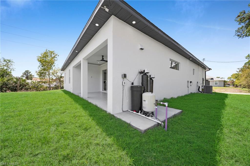 Back of property featuring a lawn, a patio area, and stucco siding
