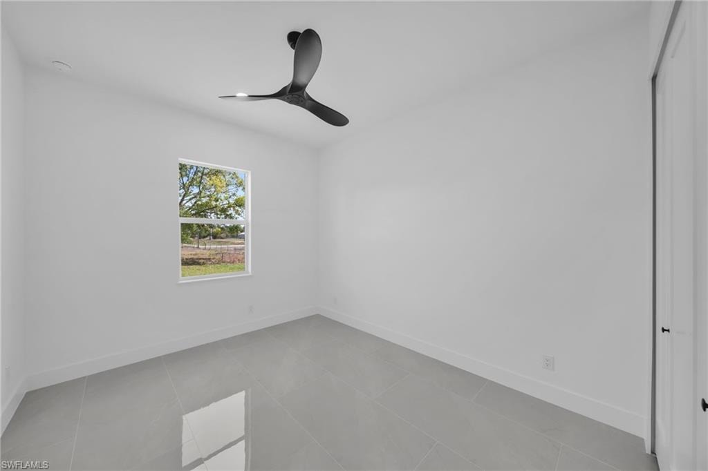 Spare room featuring a ceiling fan and light tile patterned floors