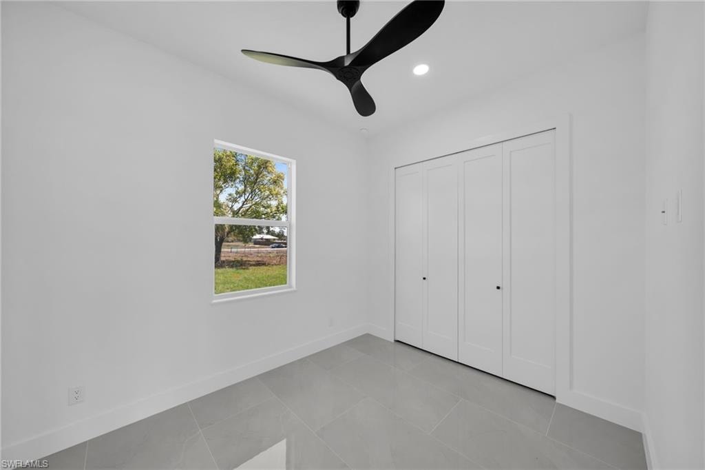 Unfurnished bedroom with a ceiling fan, a closet, recessed lighting, and light tile patterned flooring