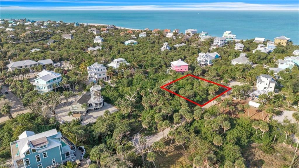 Aerial view of lot (outlined in red) with the Gulf of Mexico just beyond the tree line
